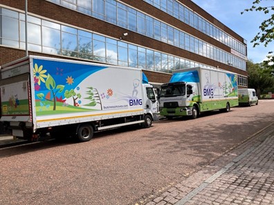 Two Business Moves Group trucks parked outside an office building