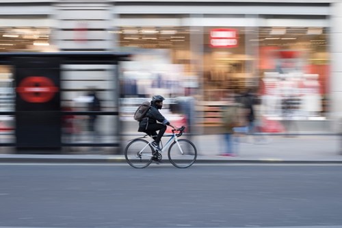 A woman cycling to work on a London street with a blurred background